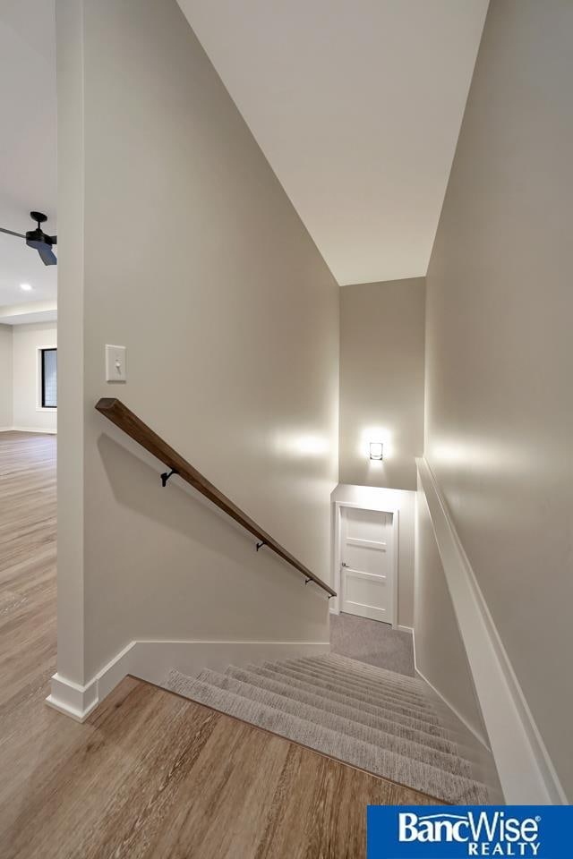 stairs with wood-type flooring and vaulted ceiling