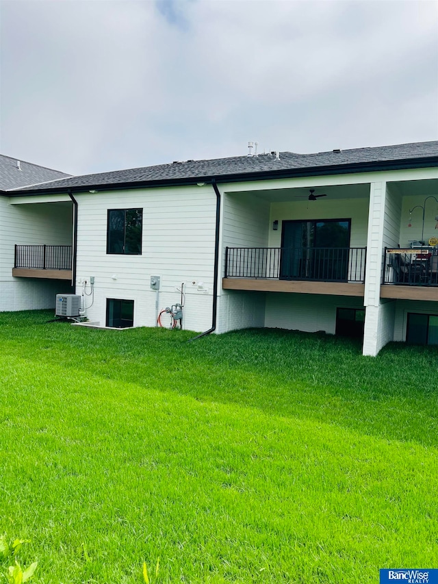 back of property with ceiling fan, central air condition unit, and a lawn