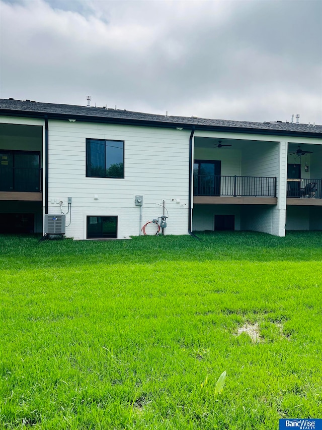 rear view of property featuring central AC unit, a yard, and ceiling fan