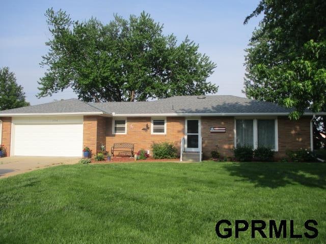 single story home featuring a front yard and a garage