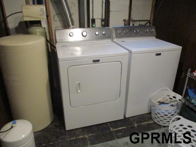 clothes washing area with dark tile patterned floors and washer and clothes dryer