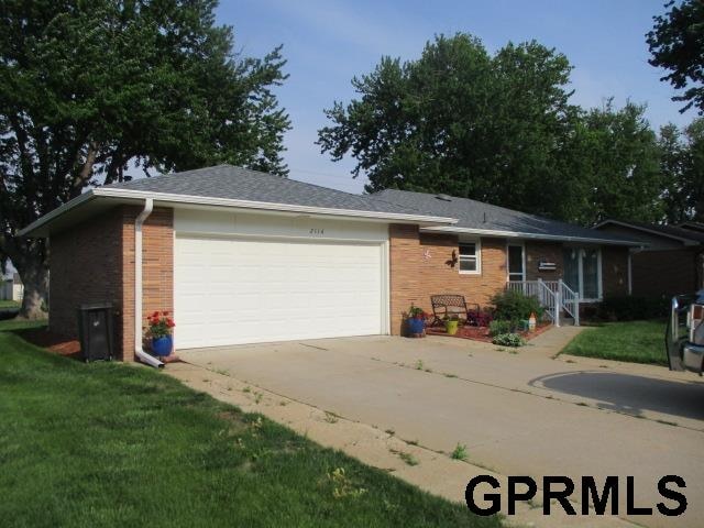 single story home with a garage and a front yard