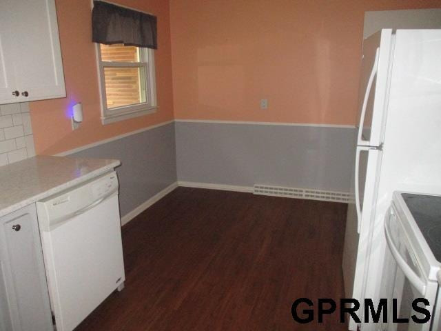 kitchen with white appliances, dark hardwood / wood-style flooring, white cabinets, and tasteful backsplash