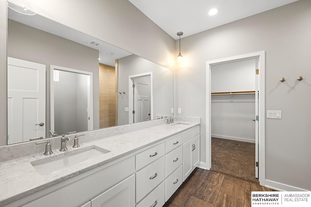 bathroom featuring hardwood / wood-style floors, a shower, and vanity