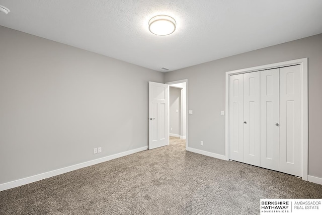 unfurnished bedroom with a closet, carpet flooring, and a textured ceiling