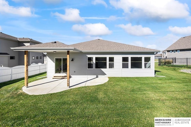 rear view of house with a patio and a yard