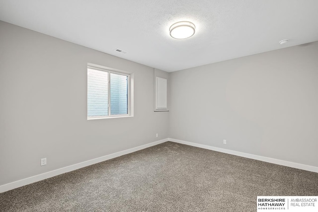 empty room with carpet and a textured ceiling