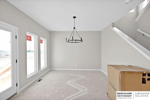 unfurnished dining area featuring a chandelier