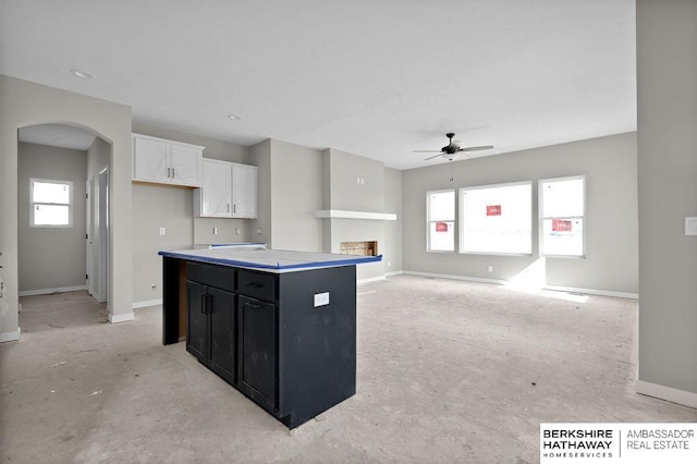 kitchen with white cabinetry, ceiling fan, and a kitchen island