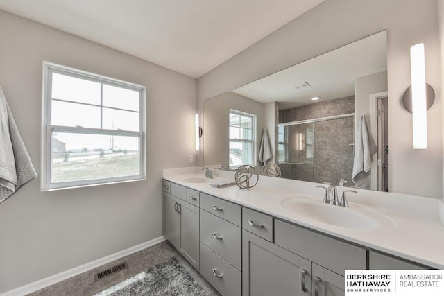 bathroom with tile patterned flooring, double sink vanity, and walk in shower