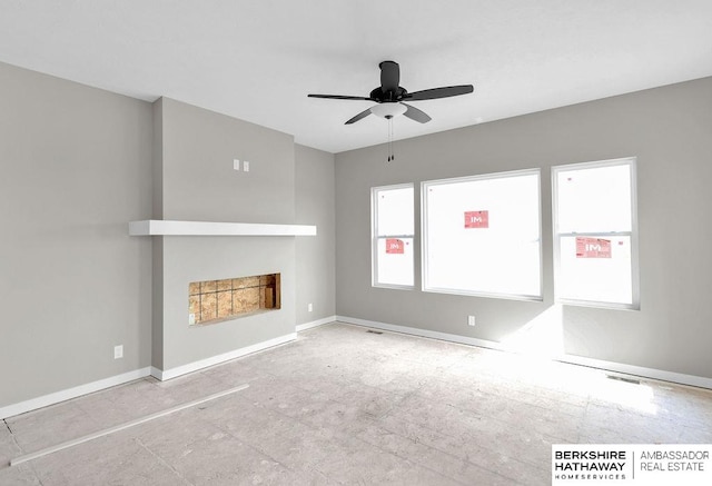 unfurnished living room with ceiling fan, plenty of natural light, and a fireplace