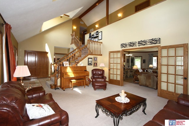 carpeted living room featuring high vaulted ceiling and french doors