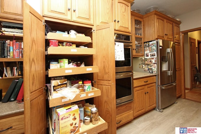 kitchen featuring appliances with stainless steel finishes and light hardwood / wood-style flooring