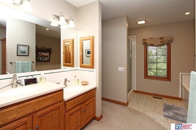 bathroom featuring walk in shower, double sink, and vanity with extensive cabinet space