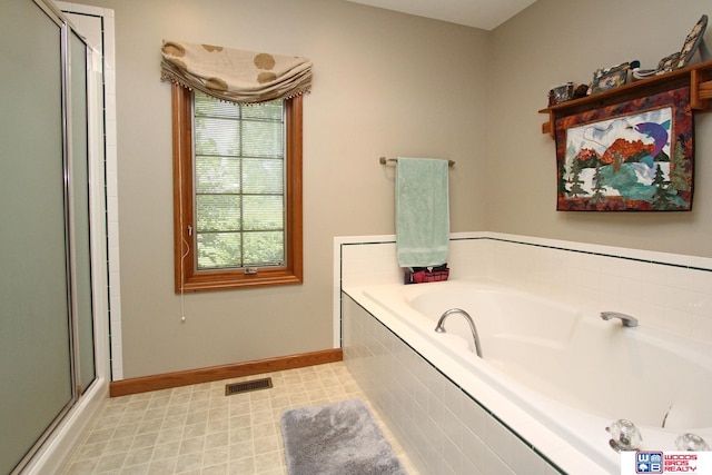 bathroom featuring a healthy amount of sunlight, separate shower and tub, and tile floors