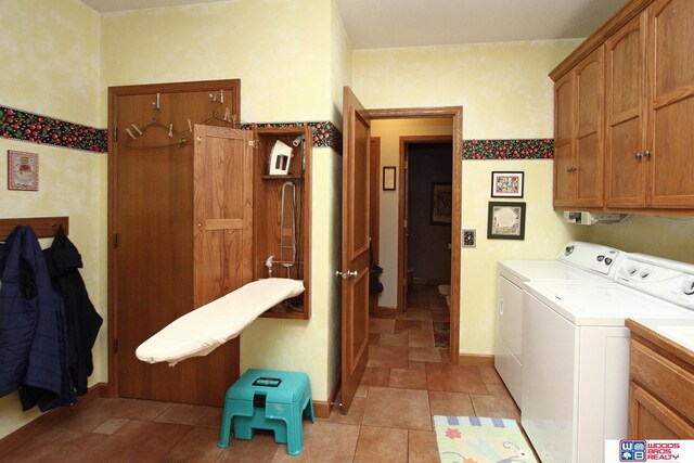 washroom with cabinets, light tile floors, and washing machine and dryer