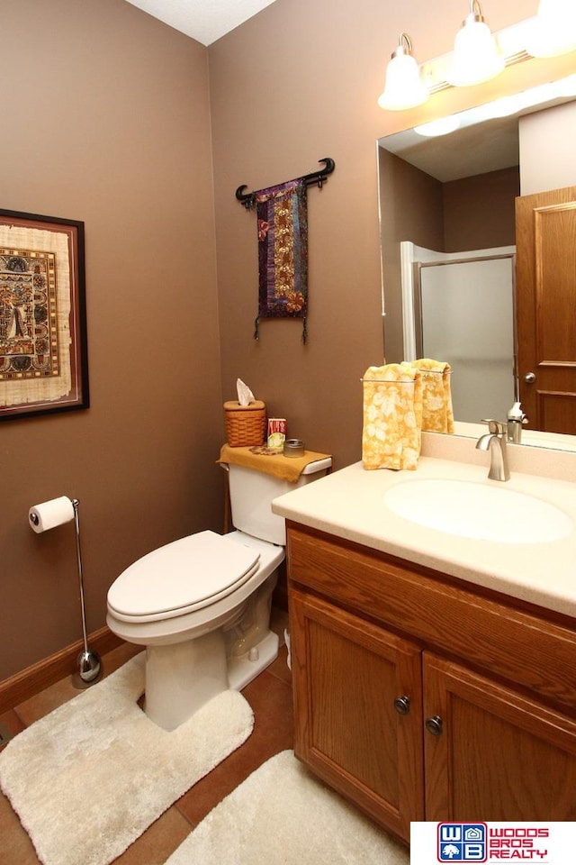 bathroom featuring vanity with extensive cabinet space, tile flooring, and toilet