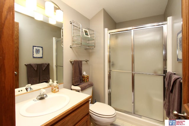 bathroom with a shower with shower door, vanity, and toilet