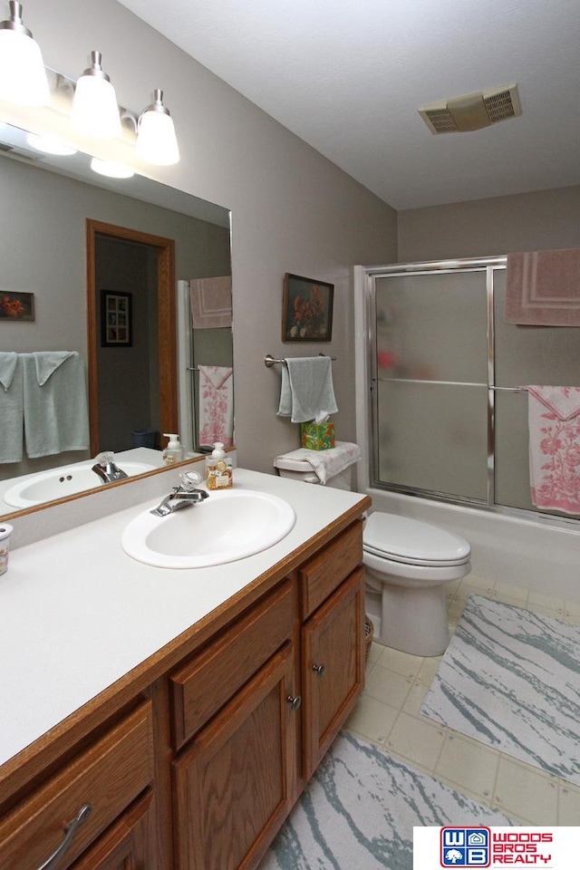 bathroom featuring tile floors, vanity, and toilet