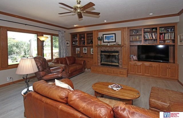 living room featuring light hardwood / wood-style floors, ornamental molding, ceiling fan, and built in features