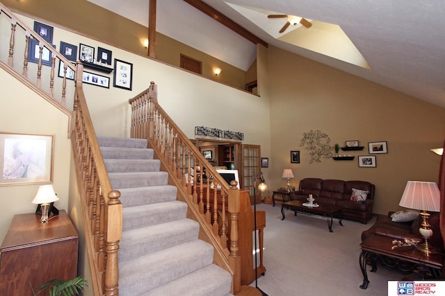 stairway featuring high vaulted ceiling, carpet floors, and ceiling fan