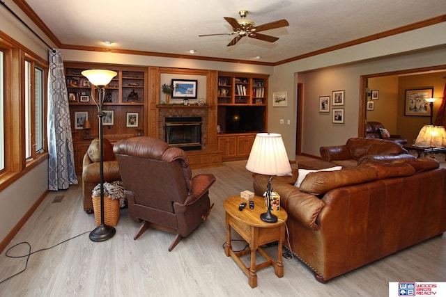 living room featuring light hardwood / wood-style floors, ceiling fan, ornamental molding, built in shelves, and a high end fireplace