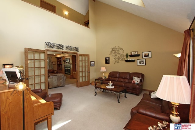 carpeted living room with high vaulted ceiling and french doors