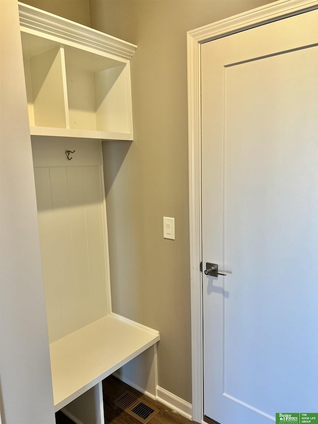 mudroom featuring baseboards and dark wood-style floors