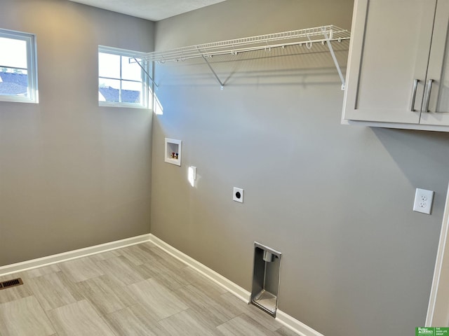 laundry room with hookup for a washing machine, hookup for an electric dryer, baseboards, and cabinet space