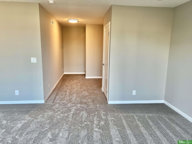 empty room with carpet, baseboards, and a smoke detector