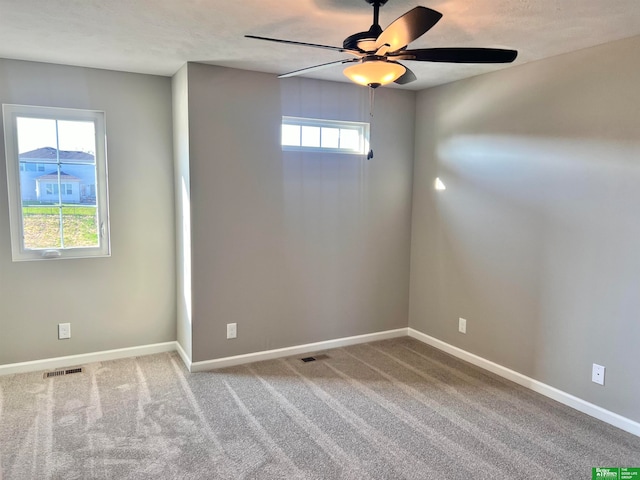 carpeted spare room with ceiling fan