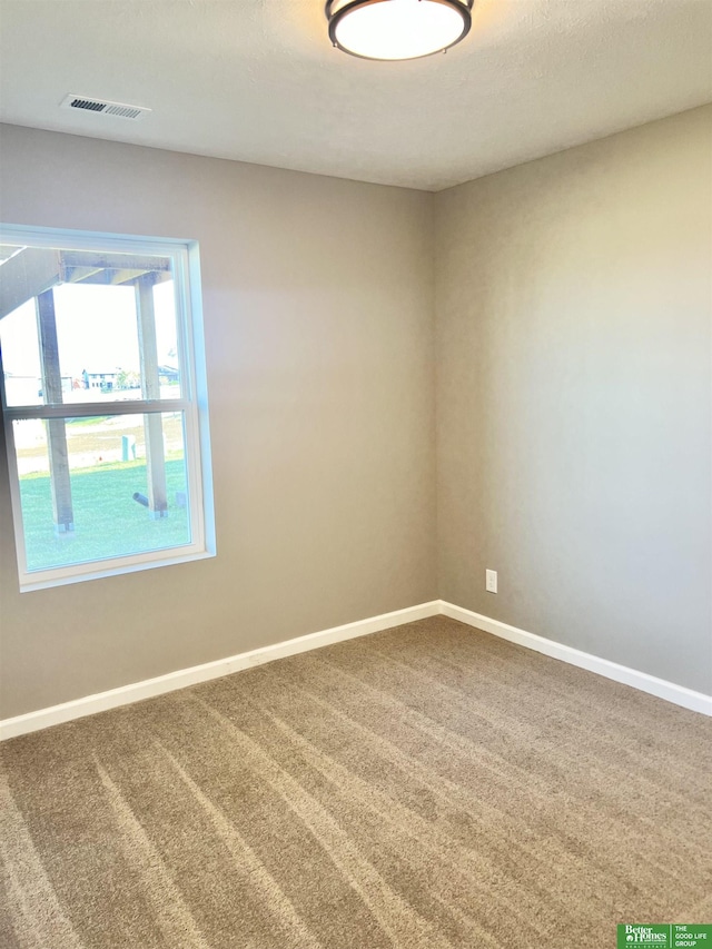 spare room with baseboards and carpet