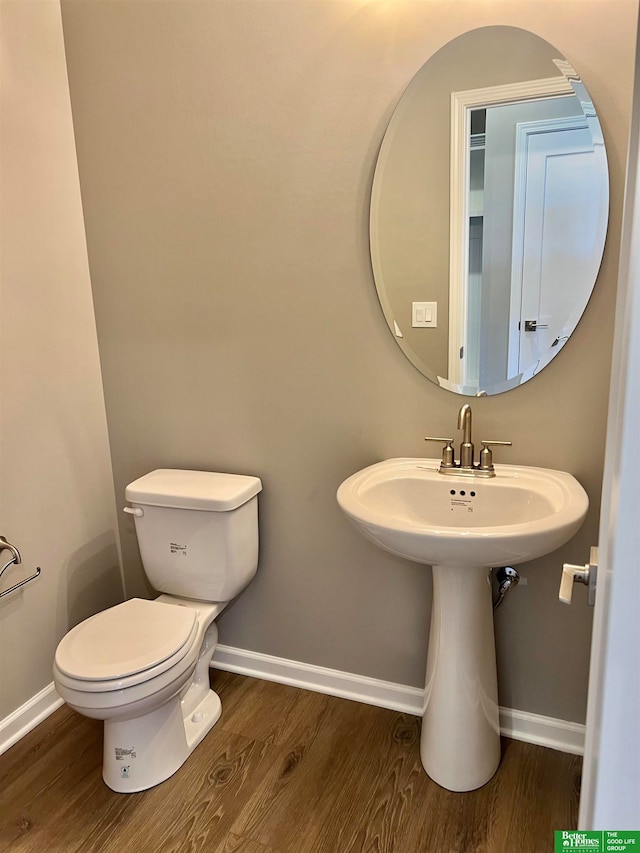 bathroom with hardwood / wood-style flooring and toilet