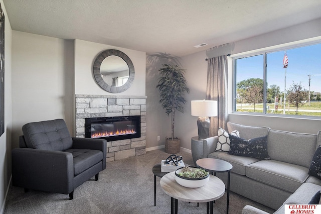 carpeted living room featuring a stone fireplace and a textured ceiling