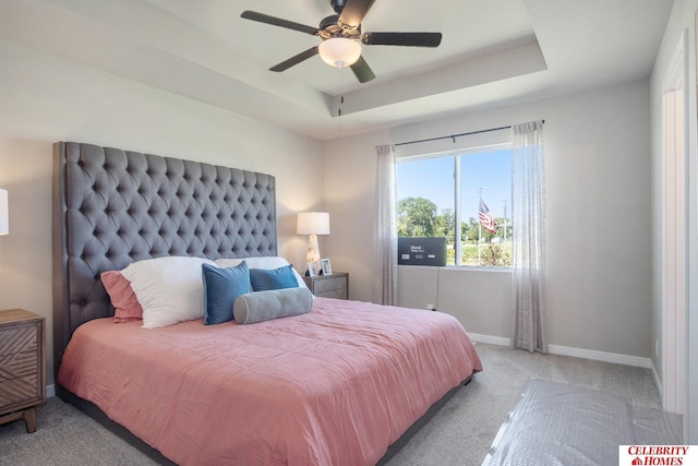 bedroom featuring light carpet, a raised ceiling, and ceiling fan