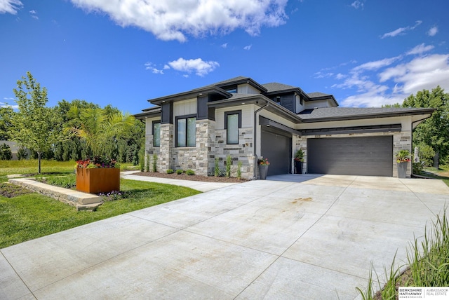 prairie-style house featuring a garage and a front yard