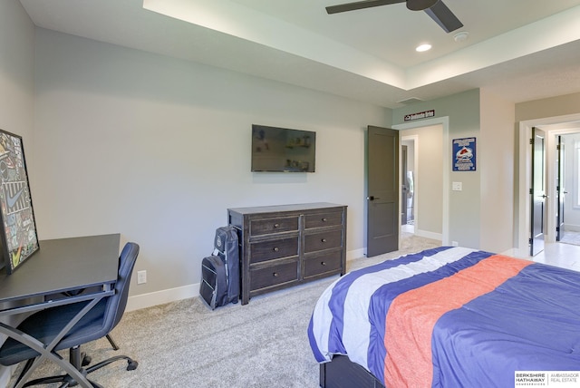 bedroom featuring ceiling fan, a raised ceiling, and light carpet