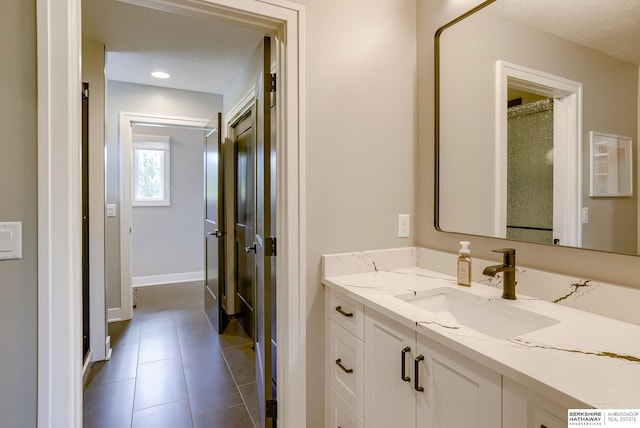 bathroom featuring vanity, tile patterned floors, and a textured ceiling