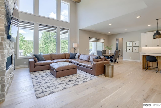 living room with light hardwood / wood-style floors and a stone fireplace