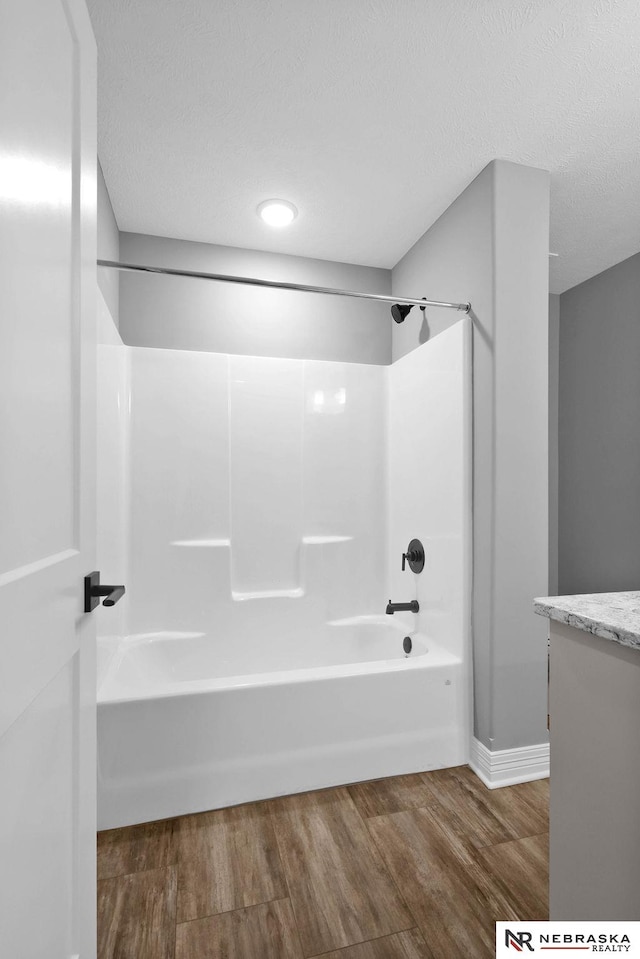 bathroom with wood-type flooring, vanity, and  shower combination