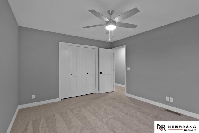 unfurnished bedroom with light carpet, a closet, and ceiling fan