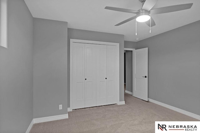 unfurnished bedroom with ceiling fan, a closet, and light colored carpet