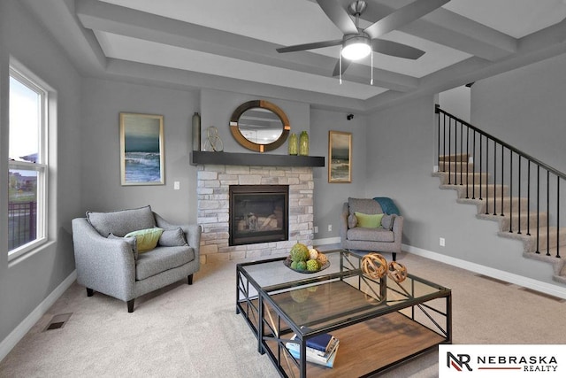 carpeted living room featuring a raised ceiling, ceiling fan, and a fireplace