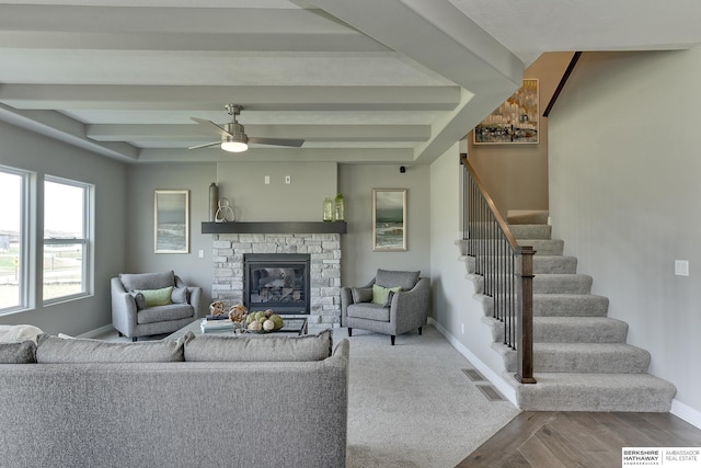 living room featuring ceiling fan and a fireplace