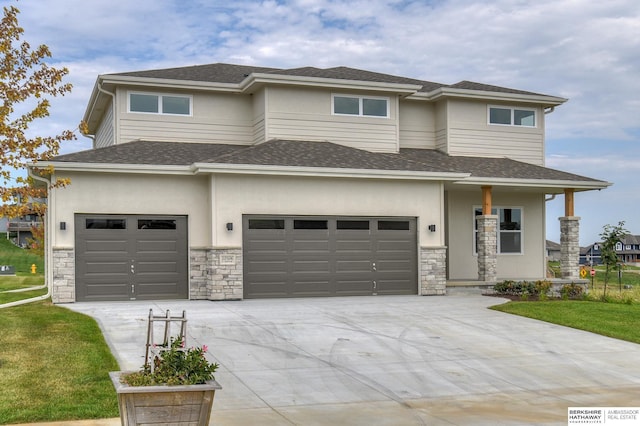 prairie-style home with a front yard and a garage