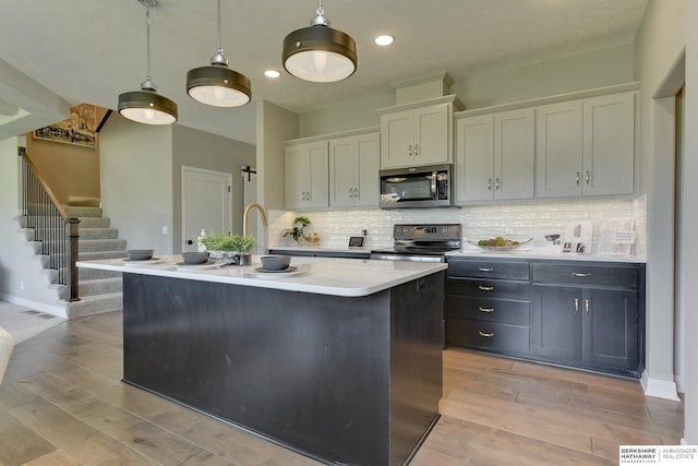 kitchen with white cabinetry, a kitchen island with sink, and appliances with stainless steel finishes