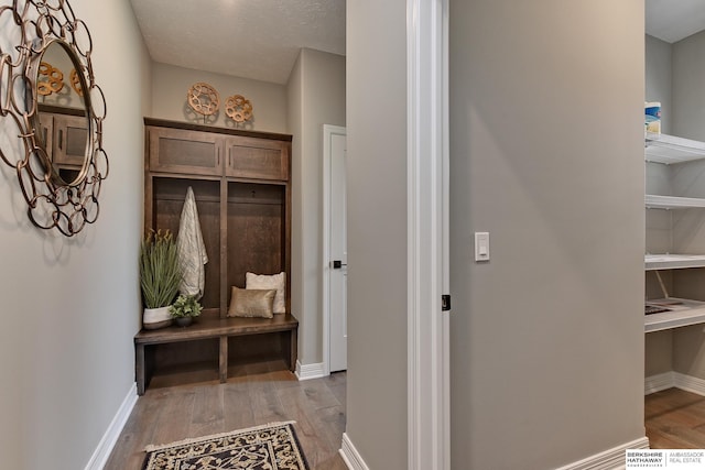 mudroom with light wood-type flooring and a textured ceiling