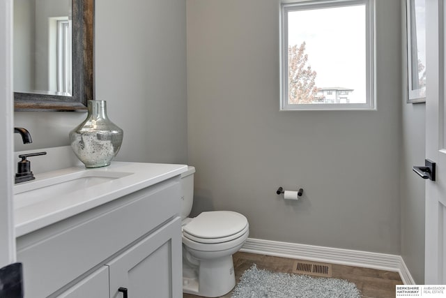 bathroom featuring vanity, wood-type flooring, and toilet