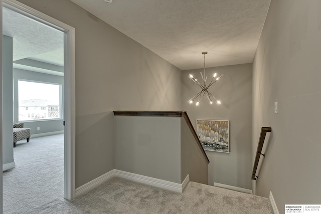 stairs with carpet flooring and a notable chandelier