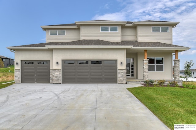 prairie-style home with a front yard and a garage